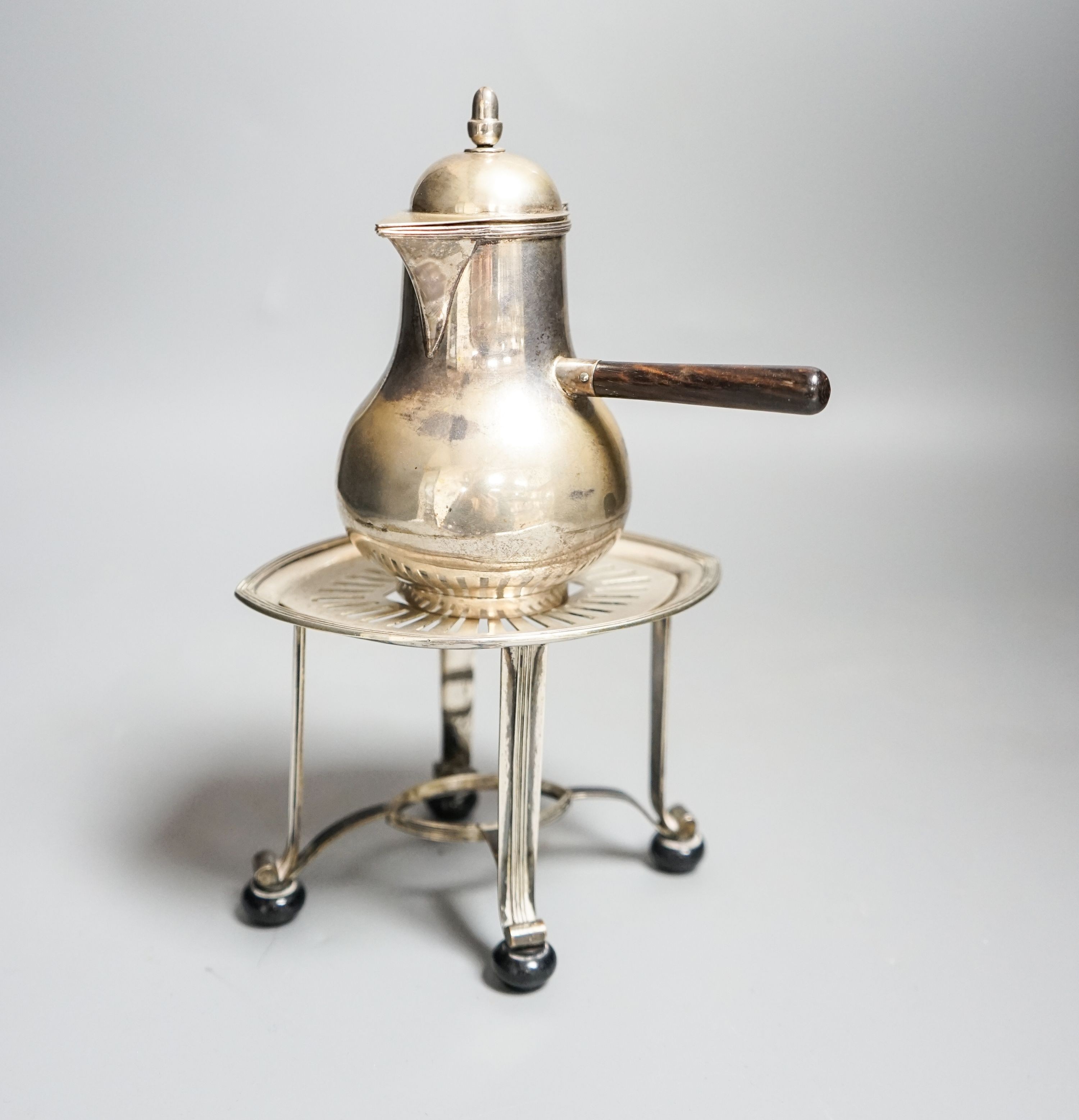 A Dutch white metal cafe-au-lait pot, with hinged cover, acorn finial and wooden handle, height 13cm, together with a Dutch white metal stand, gross 9.5oz.
